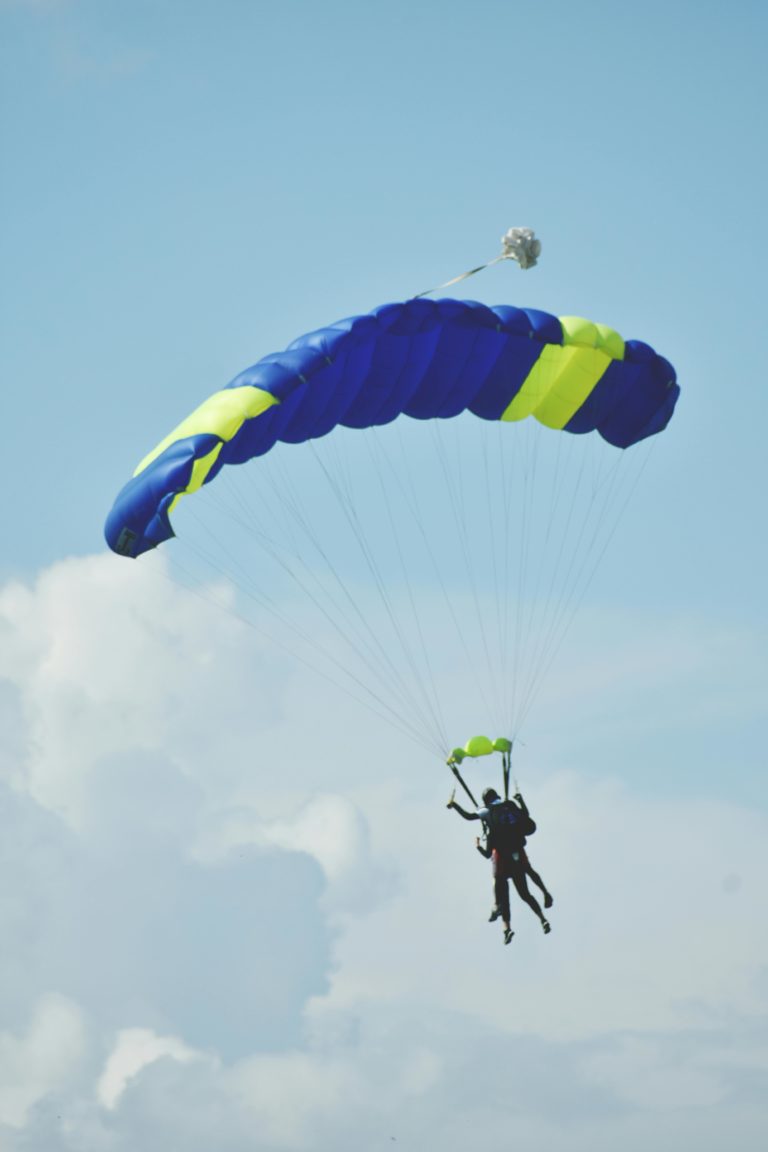 Tandem skydiving experience captured mid-air against a clear sky.